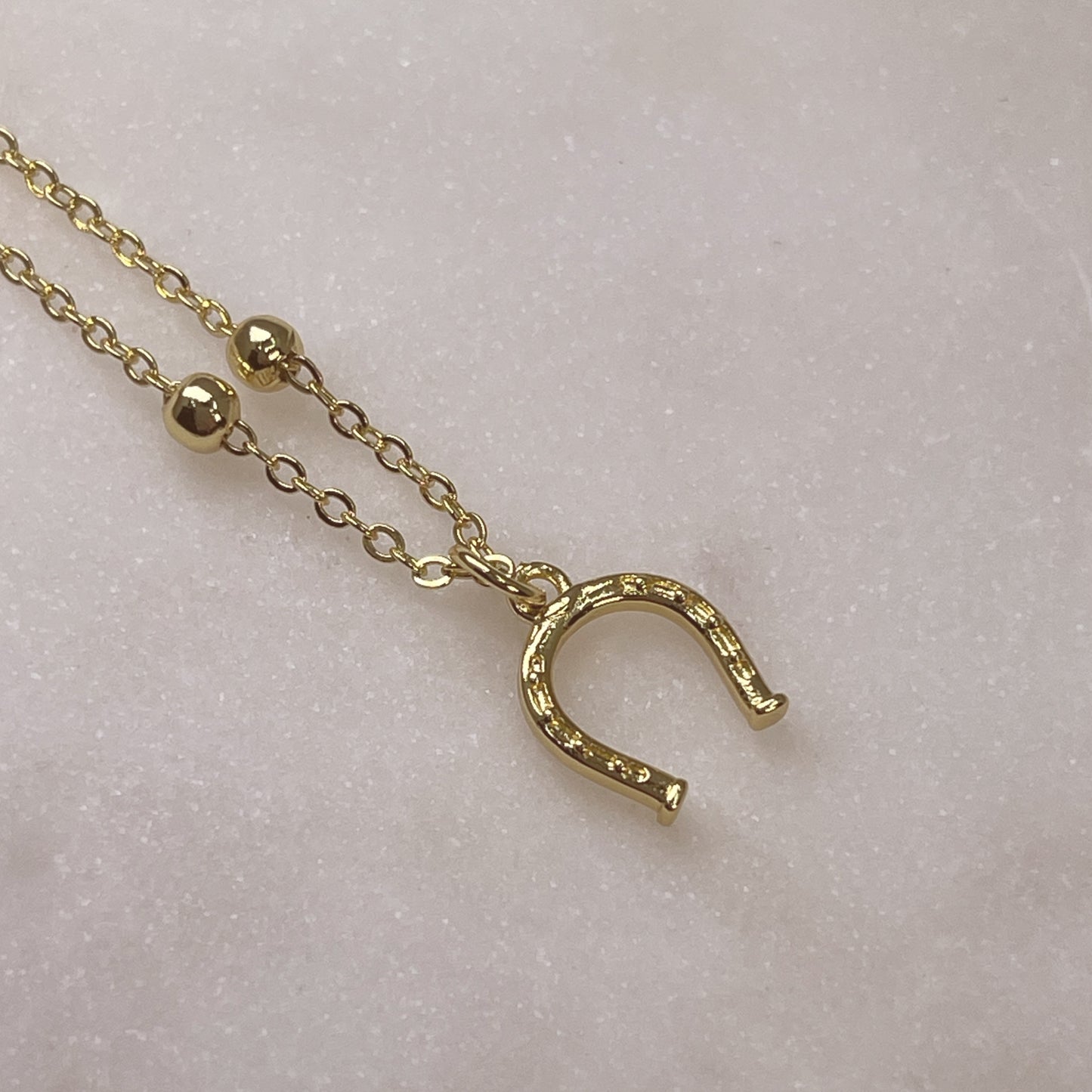 LUCKY gold horseshoe pendant on satellite chain